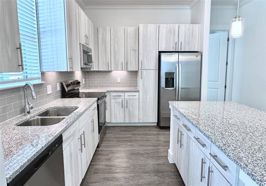 Modern kitchen with light cabinetry, lots of storage space, and window over sink with exterior views