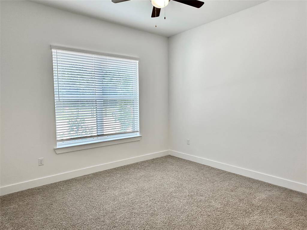 Spacious primary bedroom with window overlooking yard