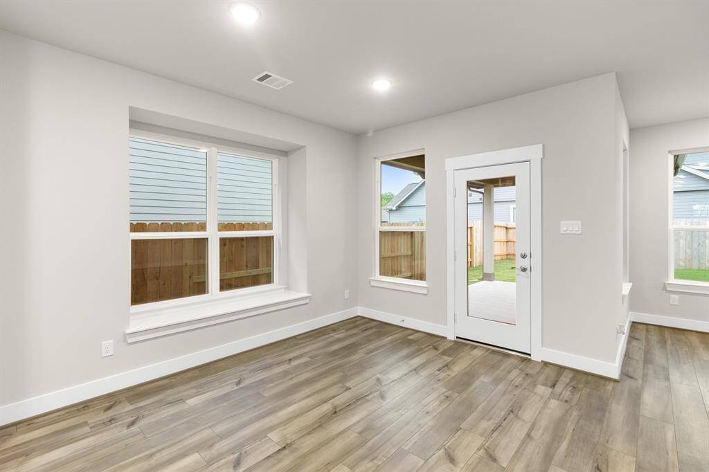 A charming nook off the dining space offers a cozy corner for morning coffee or reading, framed by expansive windows that flood the entire room with natural light.