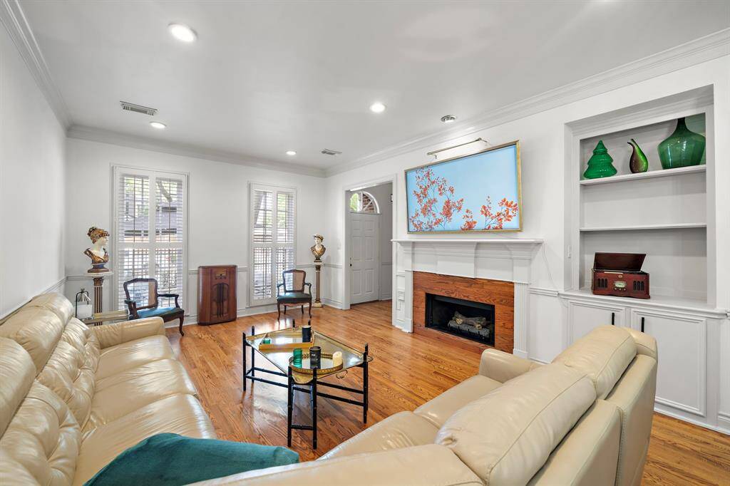 Gas log fireplace, built-in cabinetry and shelving and large windows overlooking the front patio.