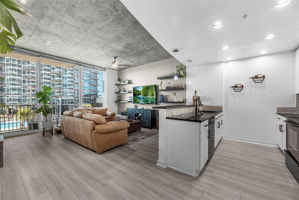 The open-concept living space features minimalist design, polished wood floors, and upscale furnishings
