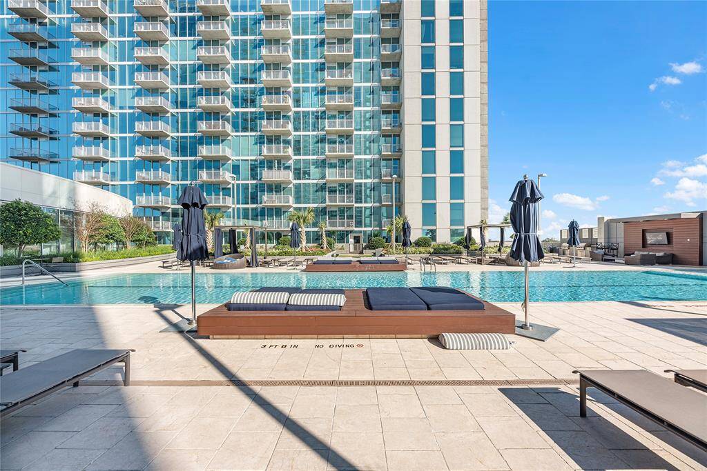 Framing a serene resort-style pool below, surrounded by lush landscaping and elegant loungers.