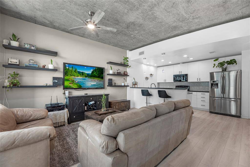 Natural light pours in, reflecting off polished hardwood floors and creating a serene, airy atmosphere perfect for both relaxation and entertaining.