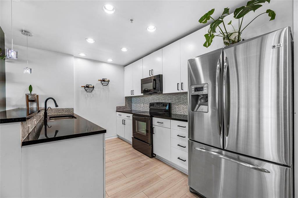 Clean lines, brushed metal hardware, and ebony countertops complete the design