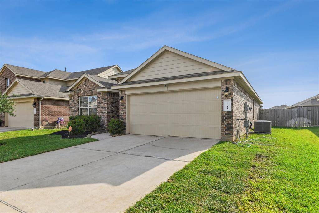 This is a single-story home with a brick and siding exterior, featuring a two-car garage and a well-maintained front yard. Located in a suburban neighborhood, it offers a clean driveway and a fenced backyard.