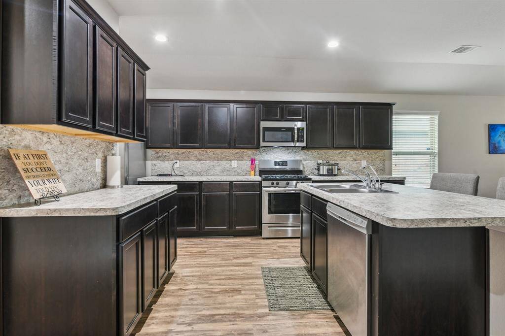 The space is well-lit with recessed lighting and has a stylish backsplash and ample countertop space.