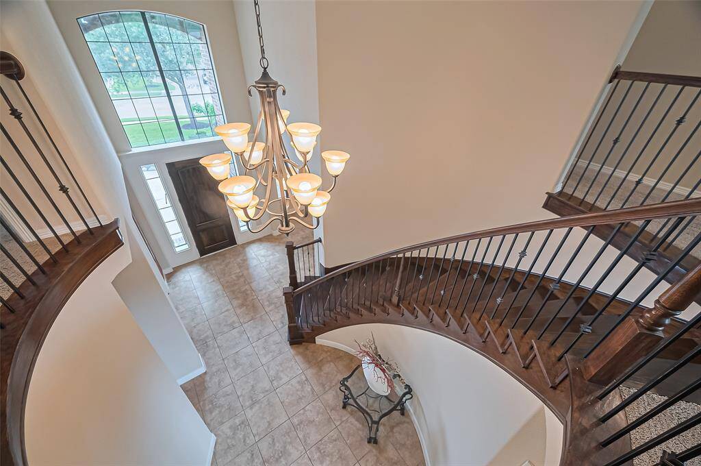 A sweeping view of the grand curved staircase—an architectural centerpiece admired from above.