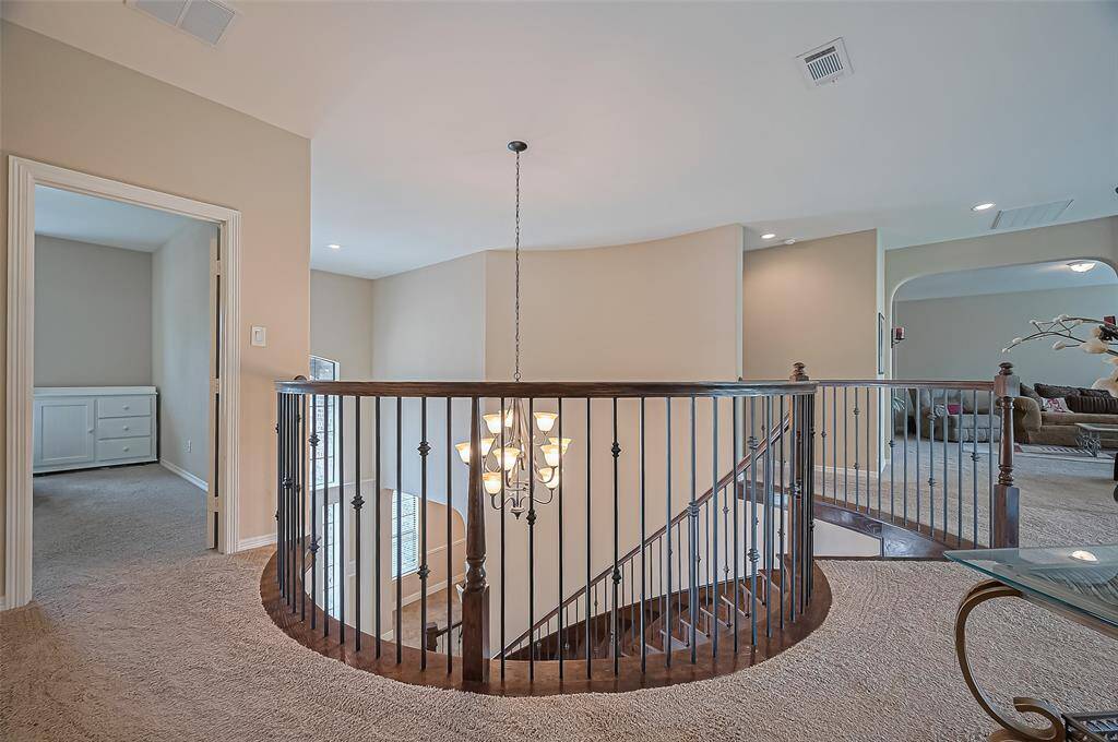 Upstairs landing connects the game room, media room, and secondary bedrooms, creating a central hub for social living.