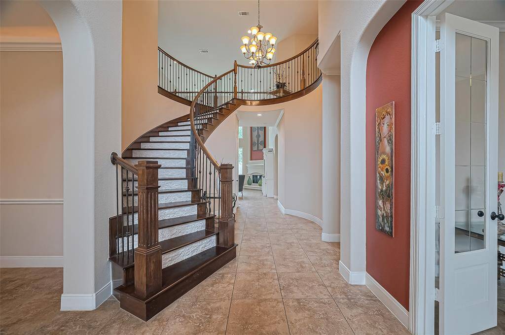 Elegant curved wooden staircase adds architectural sophistication to the foyer.