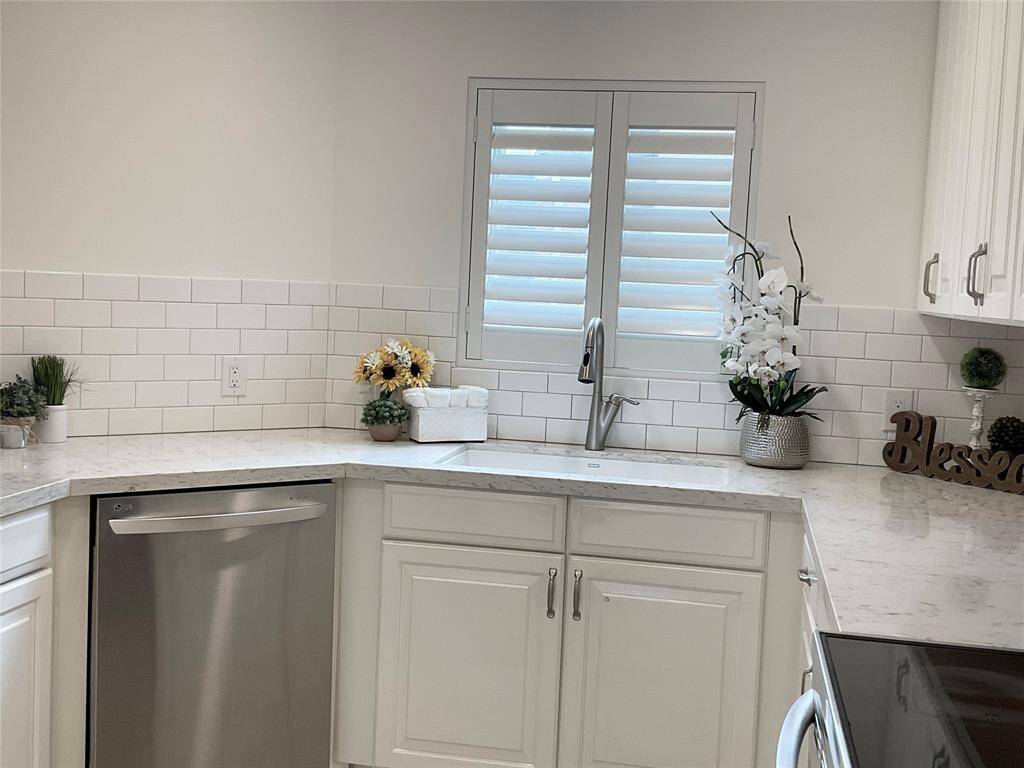 Beautiful kitchen with LG appliances, neutral-colored walls and tiled flooring, with three paneled doors, providing access to storage or additional spaces. The simple and clean design offers a versatile foundation for any decor style.
