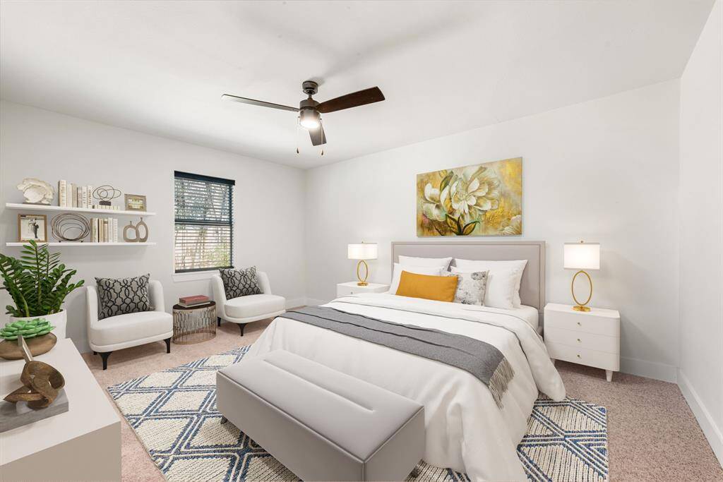 Secondary bedroom features plush carpet, custom paint, dark stained ceiling fan with lighting and a large window with plenty of natural light. *Virtually Staged