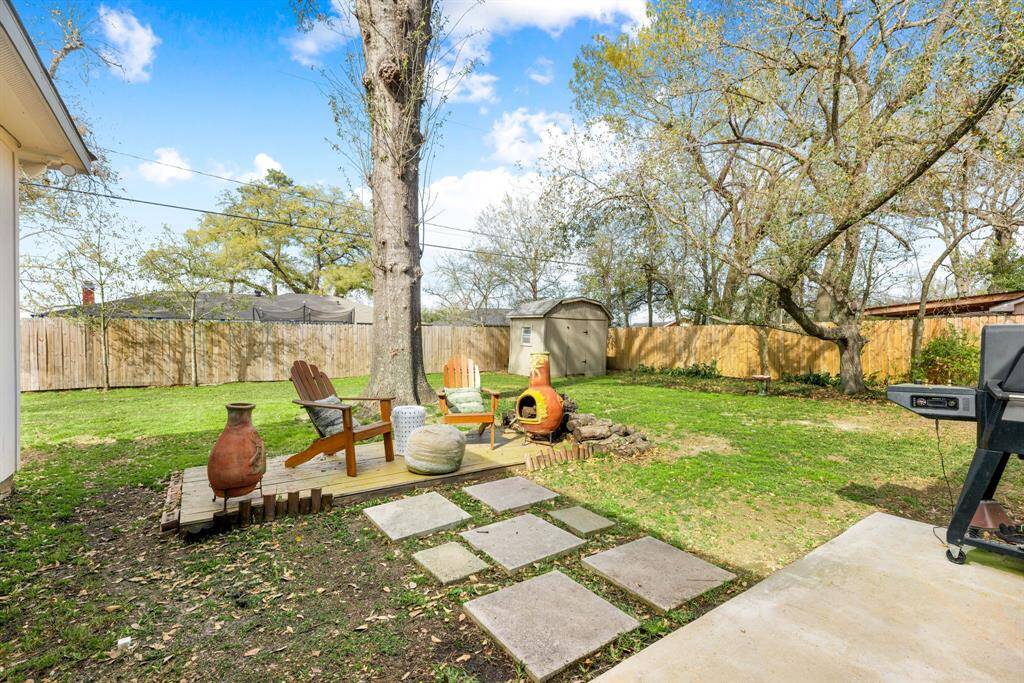 Unwind in this spacious backyard featuring a cozy seating deck, abundant green space, perfect for outdoor gatherings and everyday relaxation.