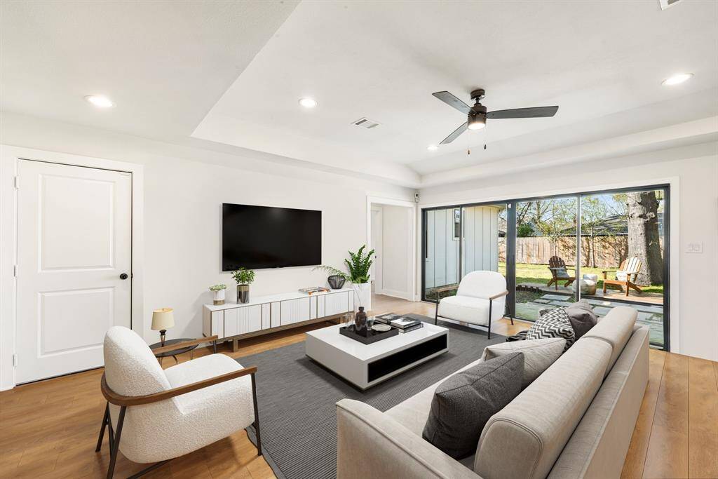 This living room is more like a GREAT room featuring custom paint, soaring high ceiling, recessed lighting, dark stained ceiling fan, and an amazing wall of windows providing a lovely view of your backyard to keep an eye out on the kids or pets playing. *Virtually Staged