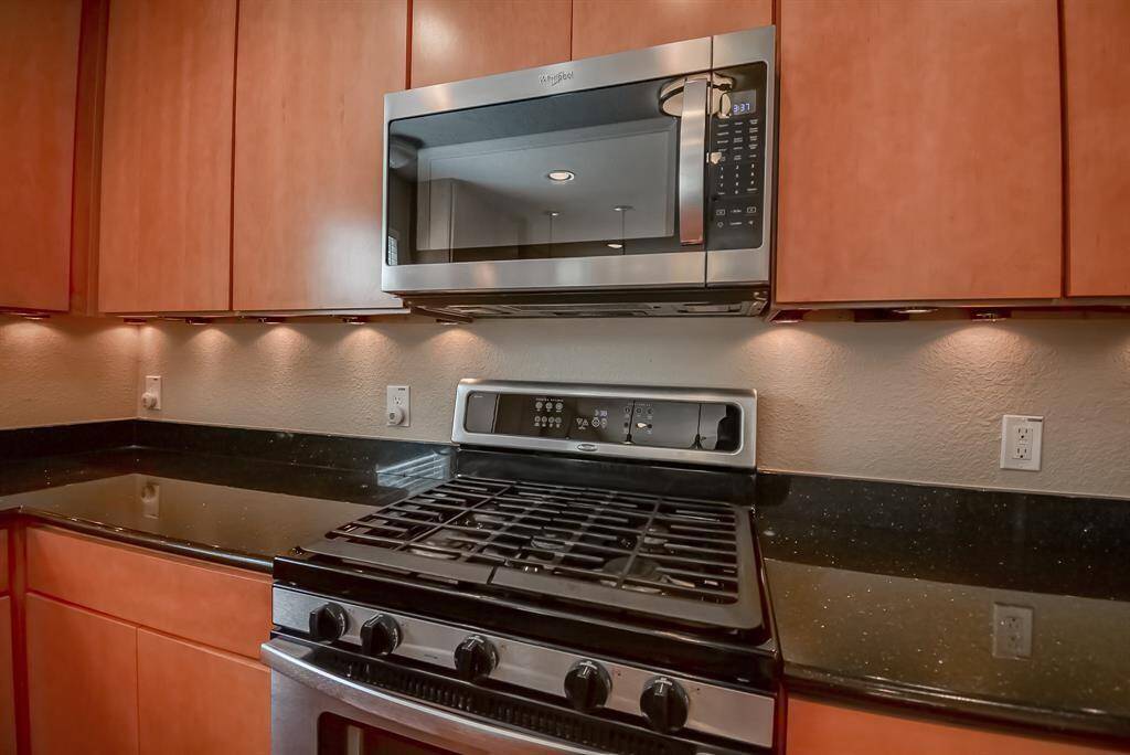 Undermount lighting, gleaming granite countertop, built-in microwave