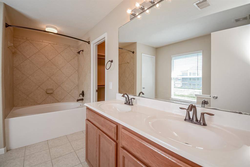 Primary bathroom boasts spacious linen closet on left and walk-in closet on right