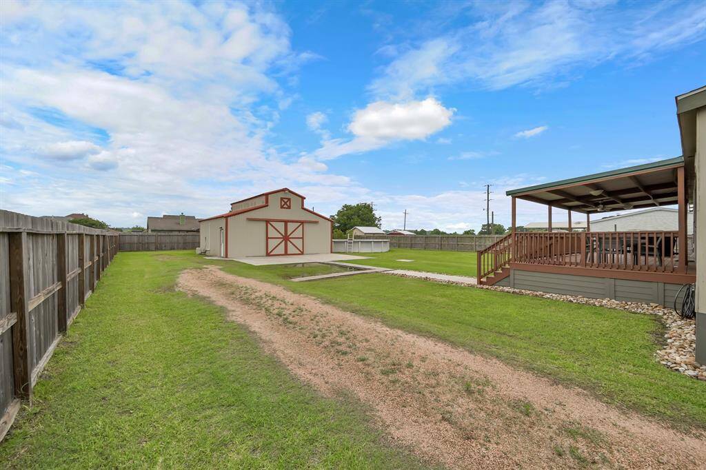 The extended driveway leads to the Workshop. The backyard is fully fenced and also features an 18k gallon above-ground pool.