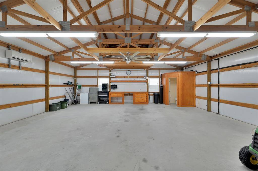 This spacious 30x30 workshop is completely insulated, air conditioned, with shelving in the back, ladder access to the upper storage, water and gas hookups, AND equipped with its own half bath.