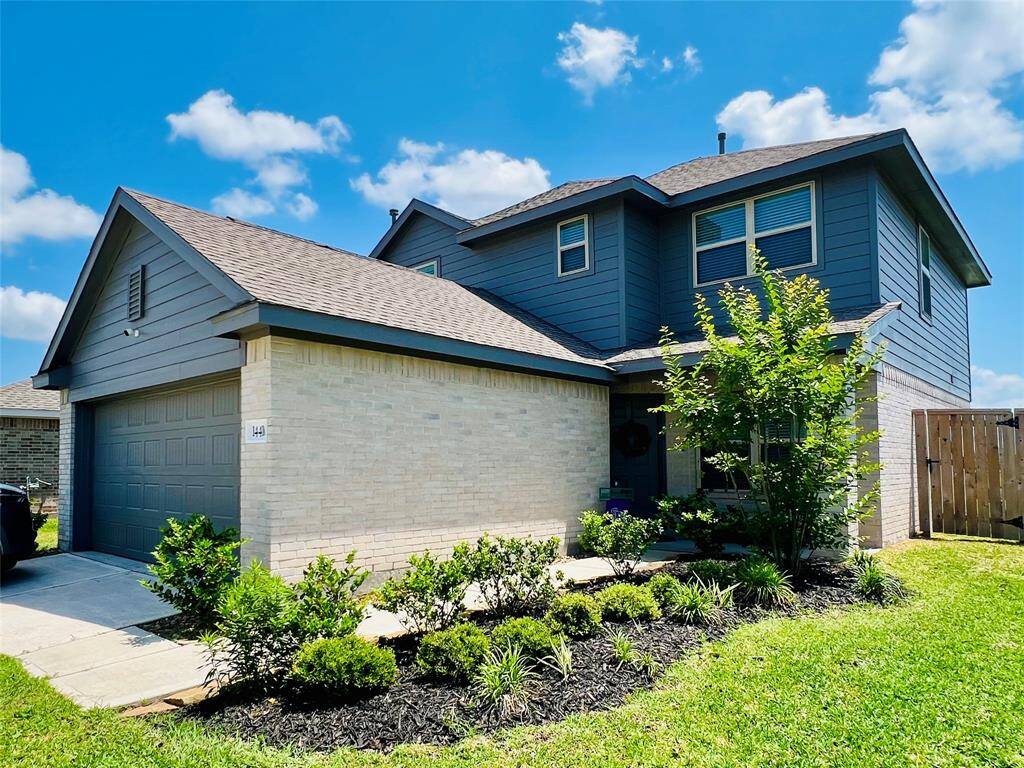 Striking modern home with beige brick and dark gray siding for a stunning contrast.