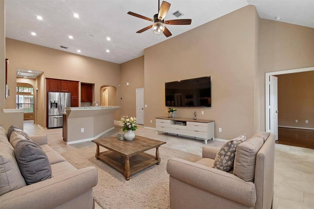 Family room features hexagon tile floors and updated ceiling fan. *Virtually staged photo*
