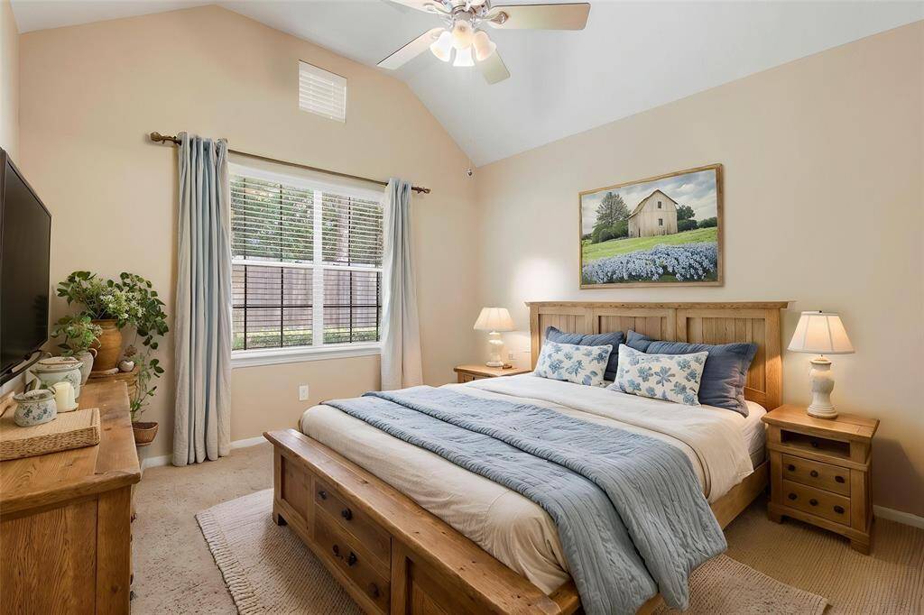 Secondary bedroom features carpet, ceiling fan and picture window. *Virtually staged photo*