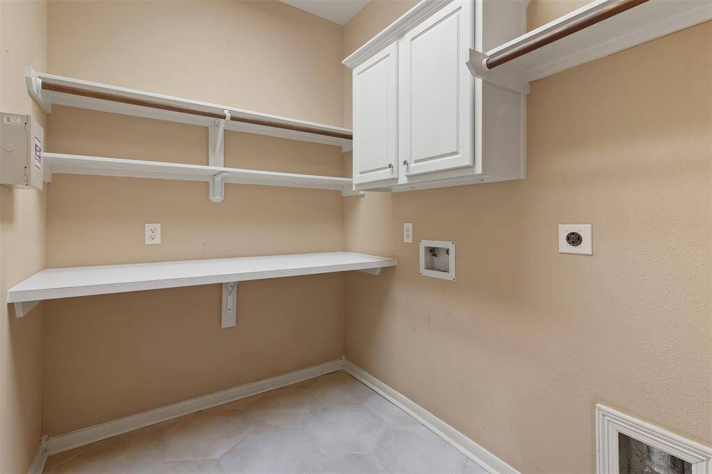Utility room in house has built in folding table and hanging/storage space.