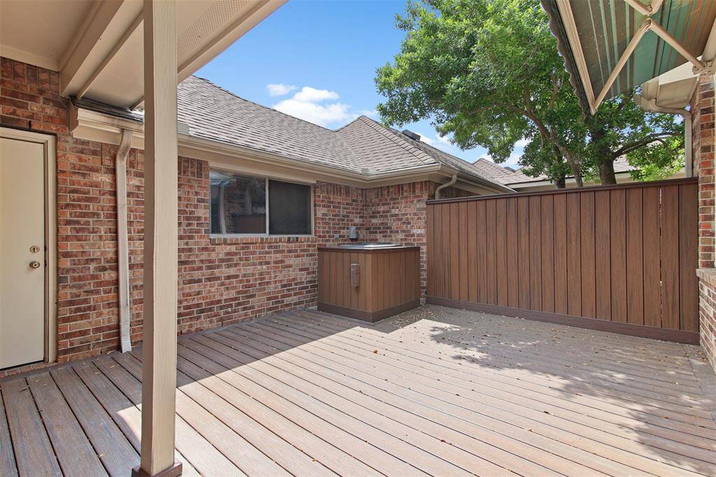 View of the backyard patio area which is perfect for outside dining. There is also a covered walkway to the detached three car garage.