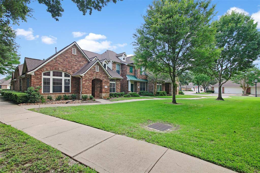 Outside area of home features trees and paved walkway.