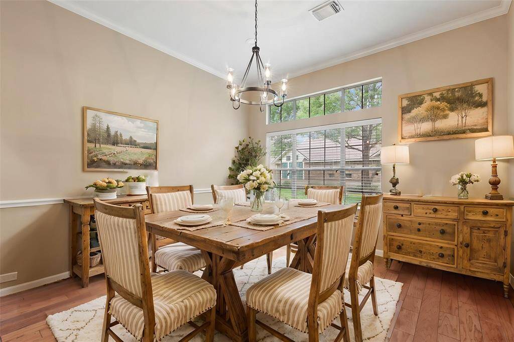 The dining room features chair rail, wood floors and large picture window. *Virtually staged photo*