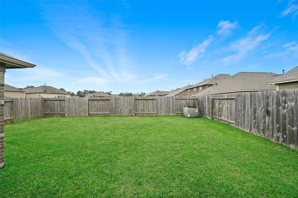 Spacious backyard with well-maintained green lawn, enclosed by a wooden privacy fence, perfect for outdoor activities and relaxation.