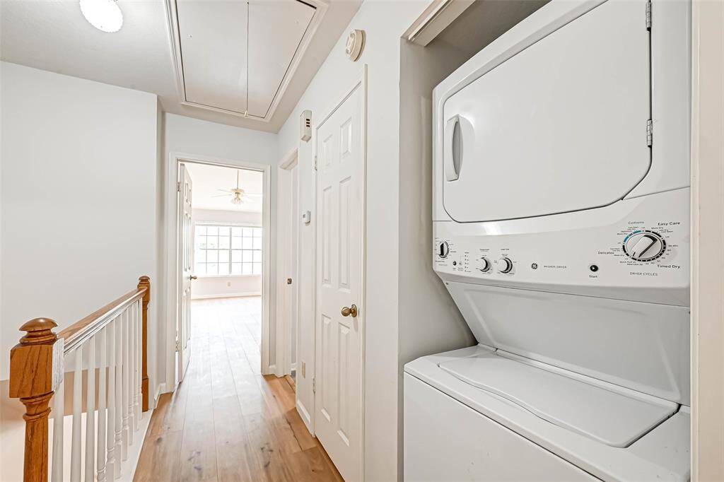Stacked washer and dryer.The hallway leading to the primary bedroom.