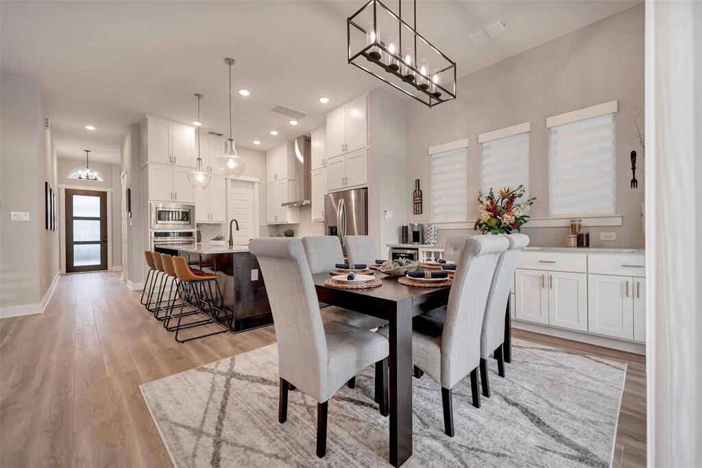 The spacious dinning area features a contemporary chandelier and upgraded butlers pantry & wine storage.