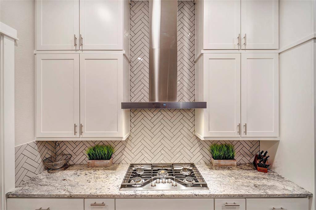 This elegant backsplash goes from counter to ceiling framing the upgraded vent hood.