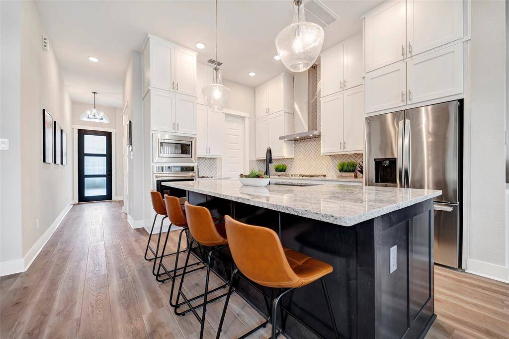 This elegant two-tone kitchen features glass pendants about the island & walk-in pantry. So much storage!