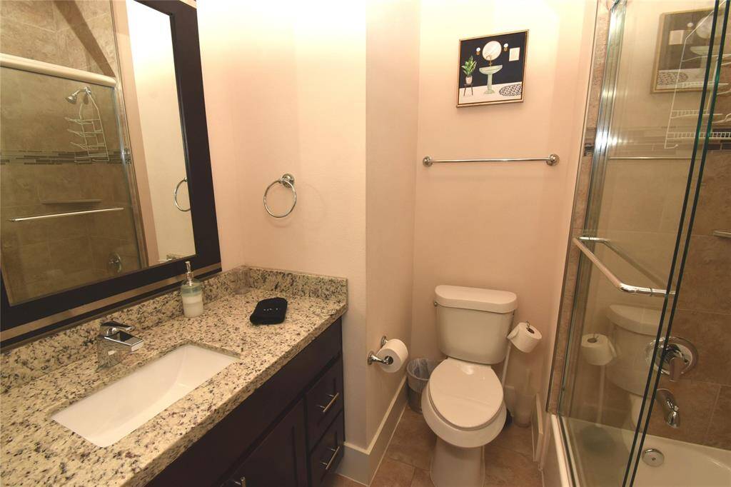 en suite bathroom showing tiled tub/shower and granite countertop