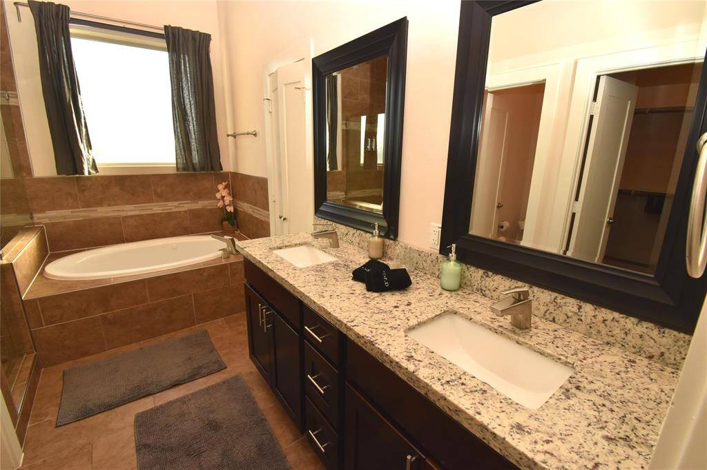 Master bath showing twin basins, granite countertop and jetted tub