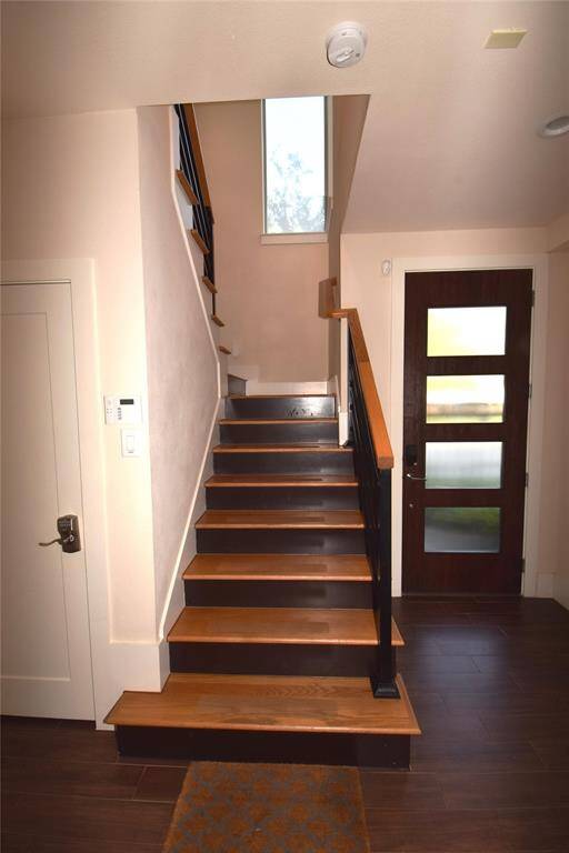 Looking toward front door from entry foyer and stairs leading to second floor kitchen and living area