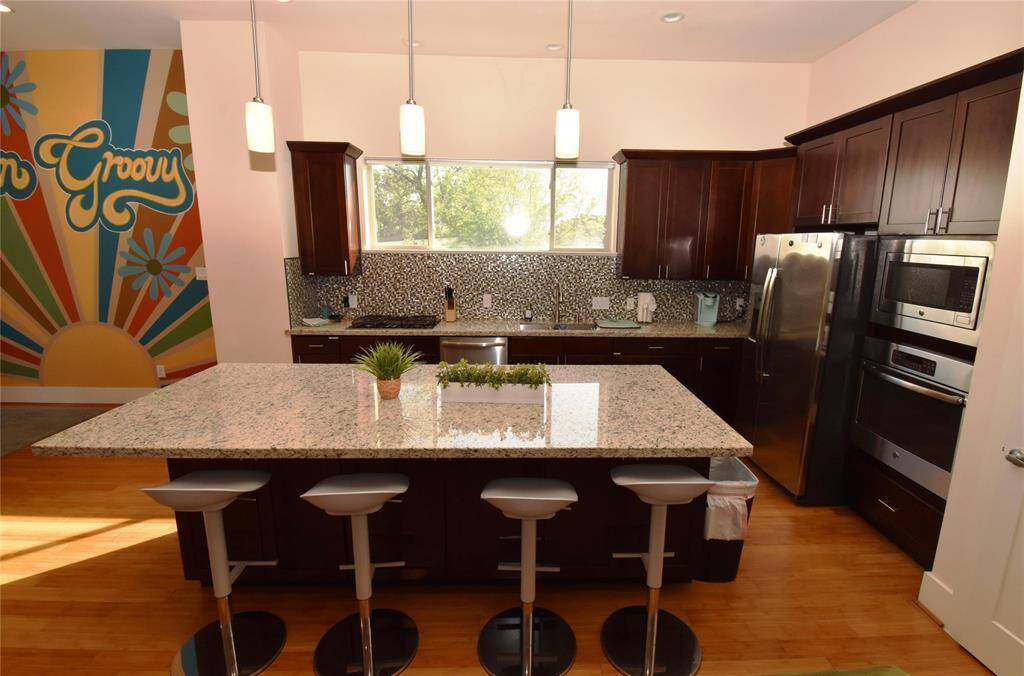 additional view of kitchen showing breakfast bar,  expansive island and stainless steel appliances