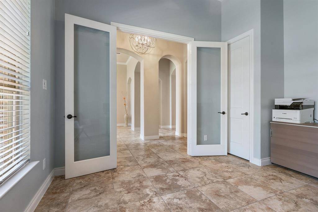 Looking out from the office into the entryway.  The arches offer architectural interest. Tile flooring resembles travertine.