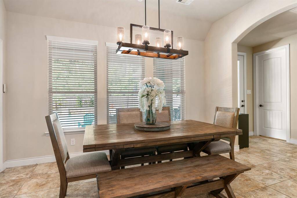 The breakfast room was enlarged when they built the home.  This room overlooks the gorgeous saltwater pool! Notice the amount of natural light from the windows. Upgraded farmhouse chandelier.
