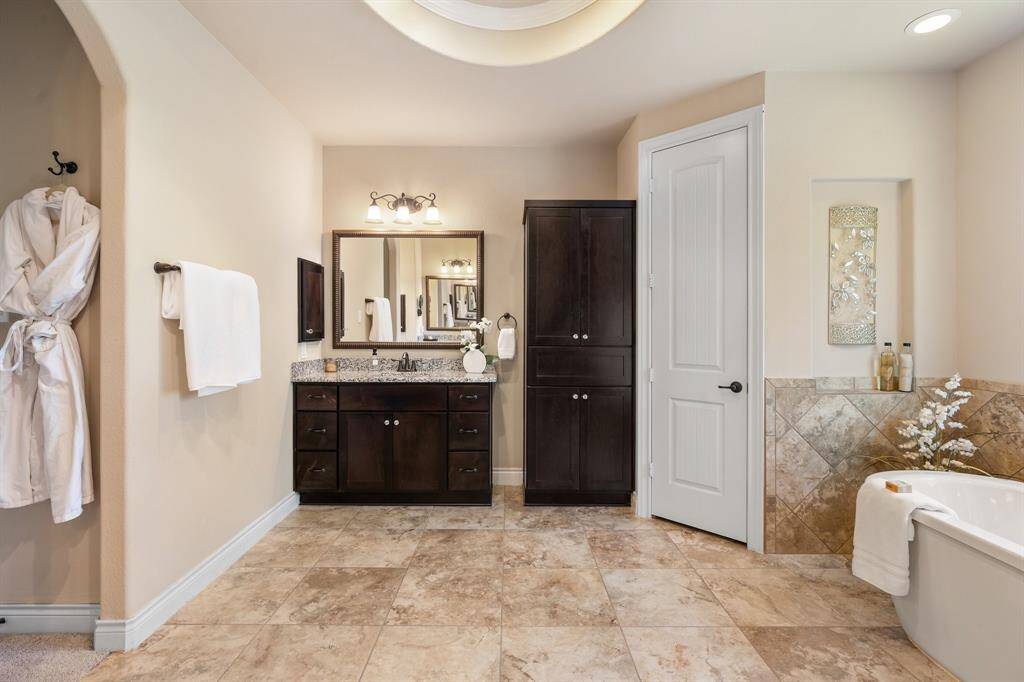The third vanity area with large tower of cabinets.  The bathroom has a spa like feel.  There are 2 large separate closets!