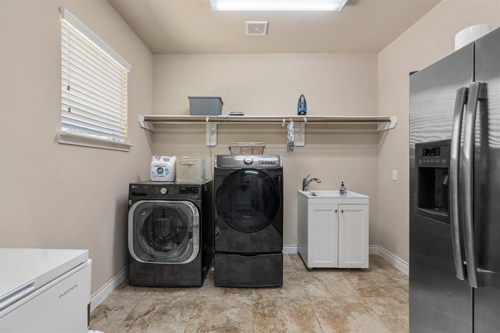 Oversized laundry room with sink and cabinet has room for all of your laundry needs!