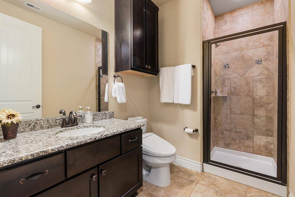 Powder bathroom features a walk-in shower.  There's a great deal of storage with the cabinets.
