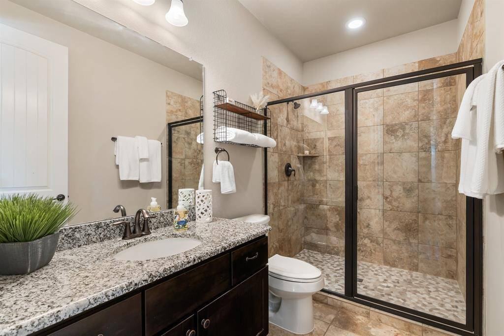 Pool bathroom is conveniently located by the backdoor that leads to the pool.  Notice the size of the shower! No need to worry about kids, or guests tracking water through your house!  This room was added on during the build.