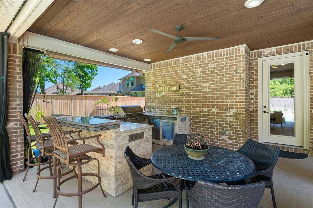 Covered back porch with functional custom outdoor kitchen provides the perfect place to entertain family and friends! Lion brand appliances with built-in gas grill, refrigerator, granite countertops and more!  Custom bug netting on a track system around the whole patio. Multiple ceiling fans on the patio to ensure your comfort.