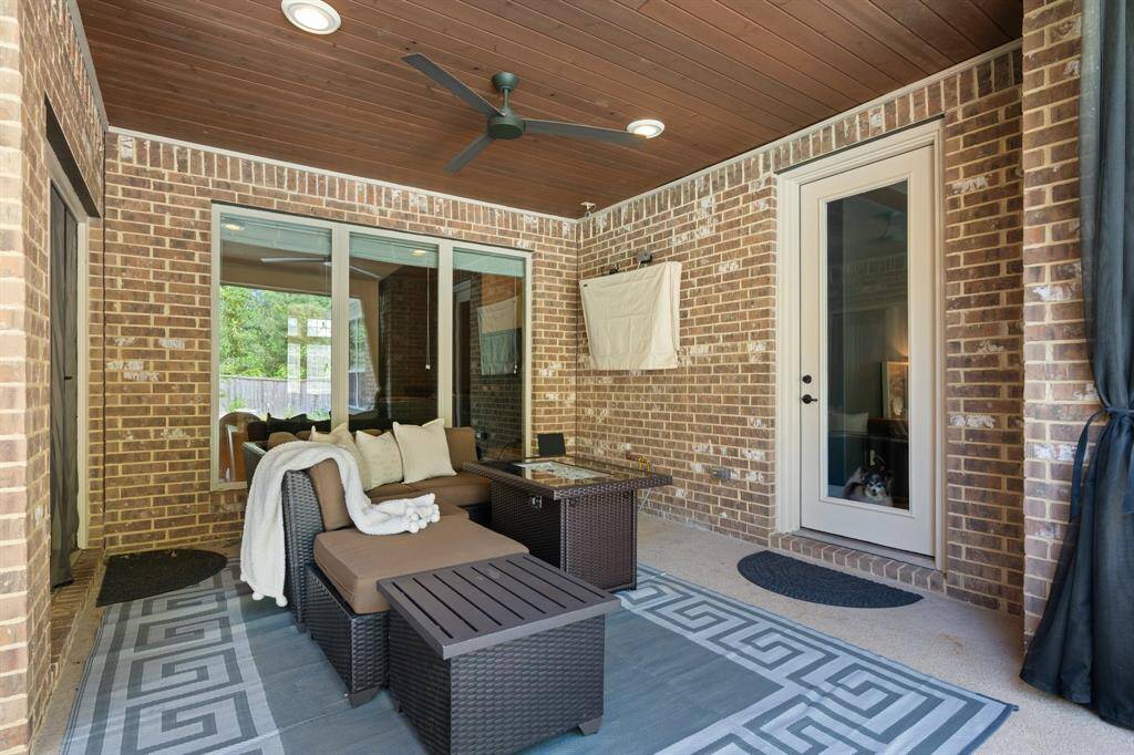 This is the covered porch that has private access through the primary suite. This porch also has the beautiful tongue and groove wooden ceiling detail with ceiling fan. There's gas access on the wall.  This patio is perfect for watching your favorite team win the big game!