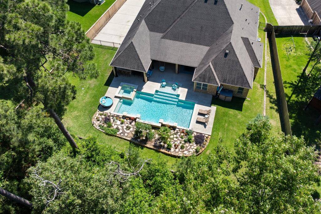 Rear aerial view showcases the beautiful backyard.