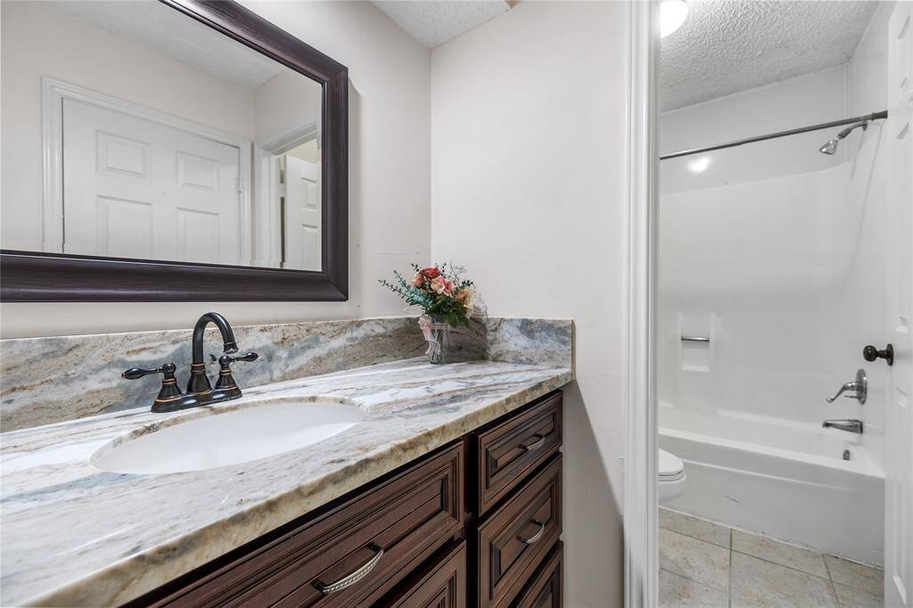 Renovated hall bathroom with granite vanity counter.