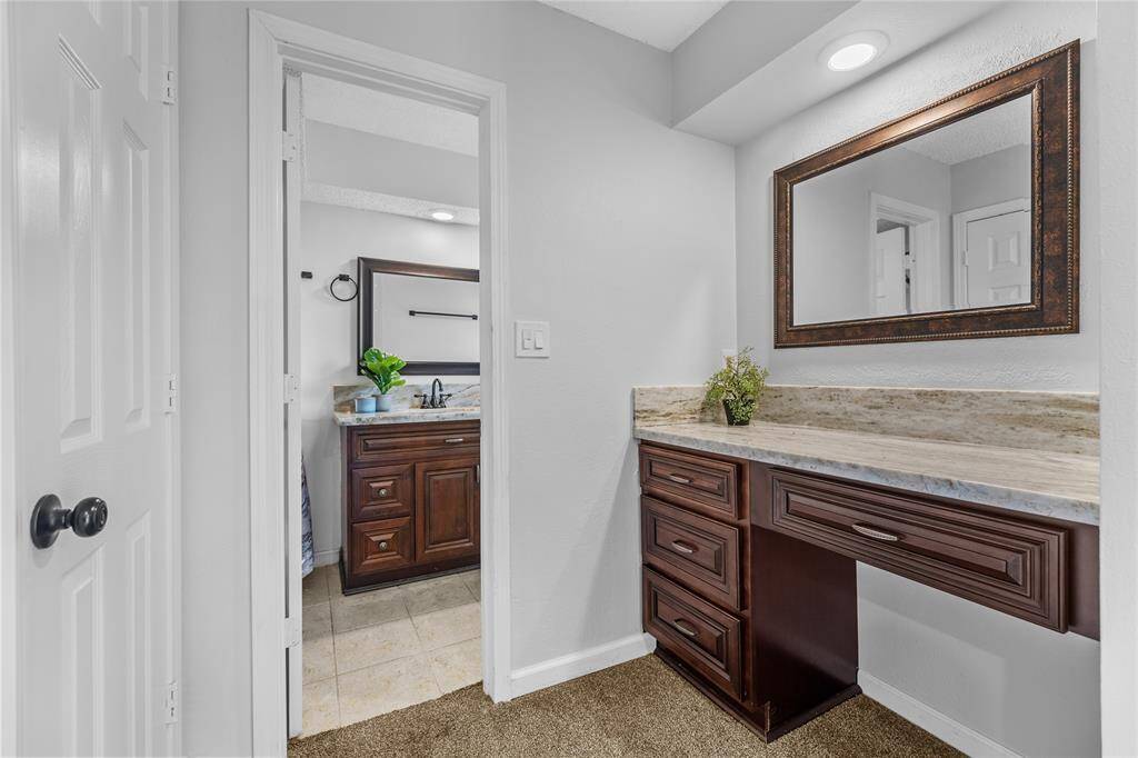 Experience the convenience of a dedicated vanity area with granite countertop in the primary suite, seamlessly connected to the en suite bathroom.