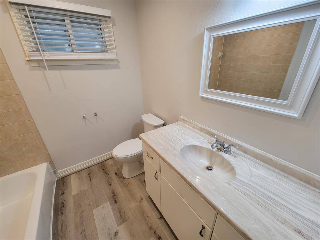 Bathroom features new flooring, refreshed tub, new toilet, fresh paint and 2 inch faux wood blinds.