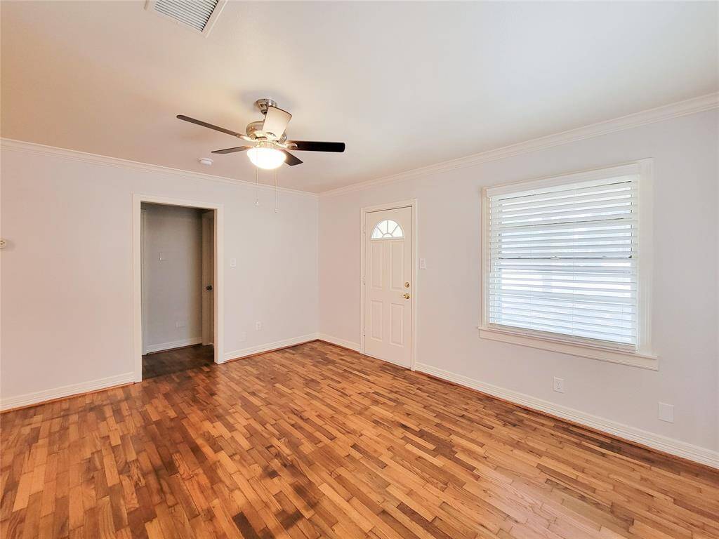 Living Room features refinished hardwoods, crown molding, fresh paint, new ceiling fan and 2 inch faux wood blinds.